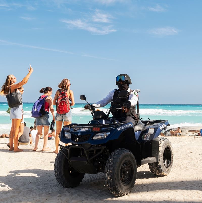 Oficial de policía en un vehículo todo terreno en una playa de Cancún, México