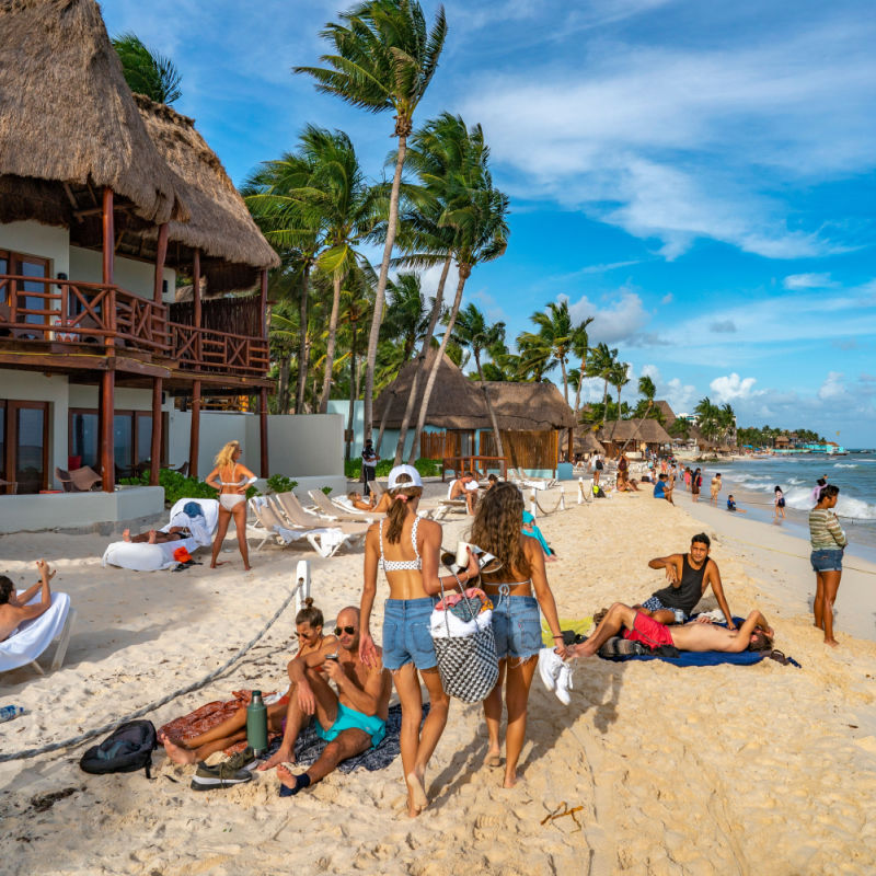 Viajeros en una playa popular en Cancún