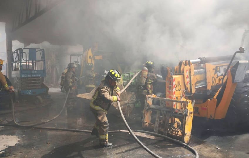 Los bomberos de la ciudad ahorran un almacén ardiente lleno de equipos pesados