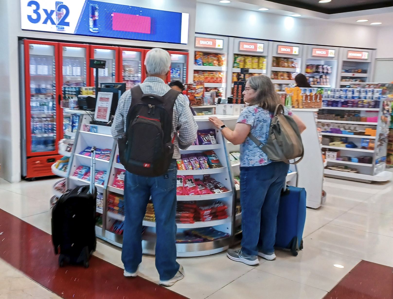Viajeros comprando snack en el aeropuerto de Cancún