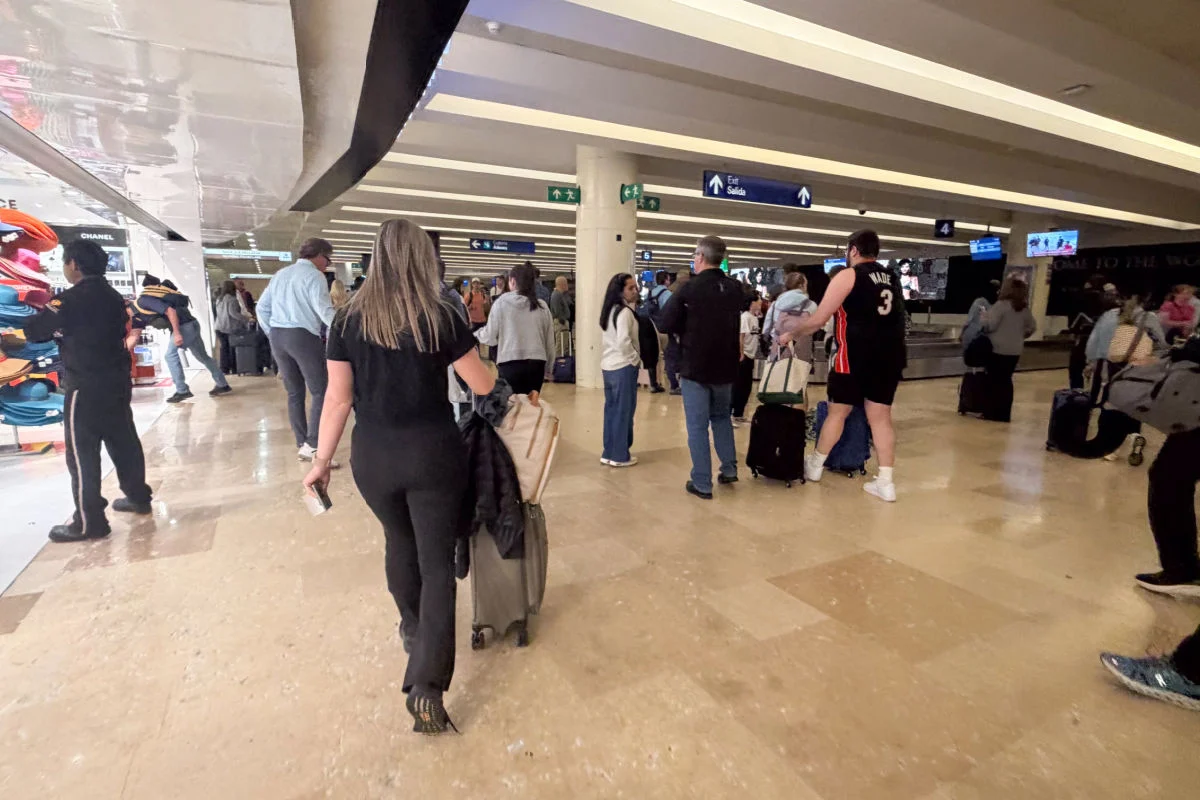 Mujer caminando por el área de equipaje del Aeropuerto de Cancún solo con equipaje de mano