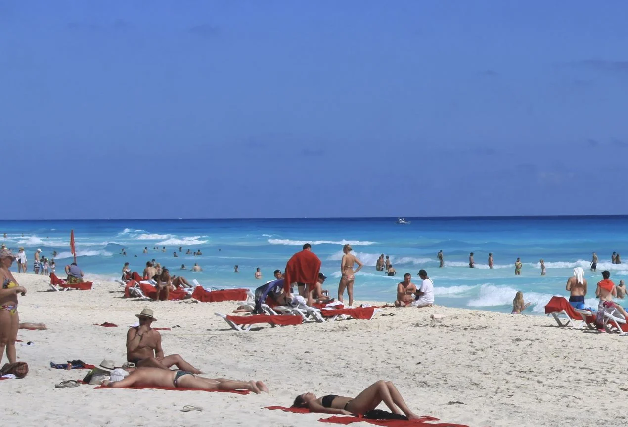 Viajeros americanos en la playa de Cancún