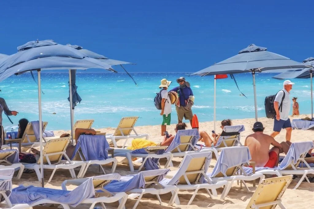 Viajeros en la playa hablando con vendedores